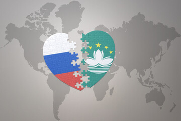 puzzle heart with the national flag of russia and Macau on a world map background. Concept.