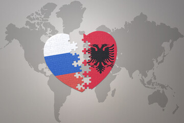 puzzle heart with the national flag of russia and albania on a world map background. Concept.