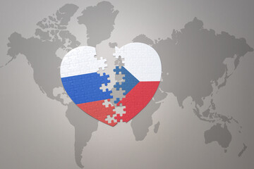 puzzle heart with the national flag of russia and czech republic on a world map background. Concept.