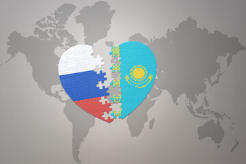 puzzle heart with the national flag of russia and kazakhstan on a world map background. Concept.