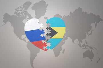 puzzle heart with the national flag of russia and bahamas on a world map background. Concept.