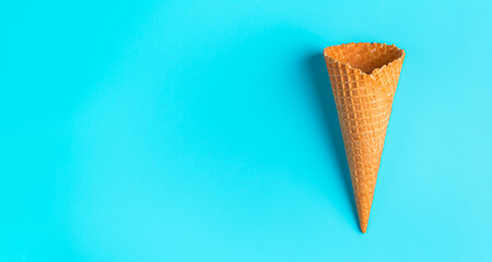 An empty ice cream cone on a blue background. View from above.