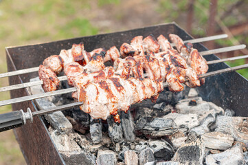 Marinated shashlik preparing on a barbecue grill over charcoal. Shashlik or Shish kebab popular in Eastern Europe