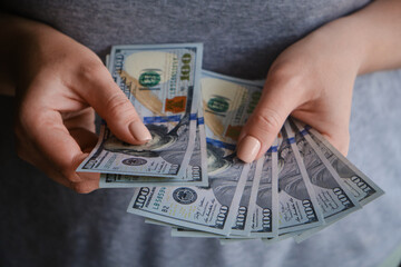 Close-up of female hands with dollar banknotes