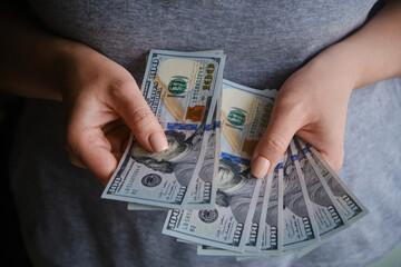 Close-up of female hands with dollar banknotes