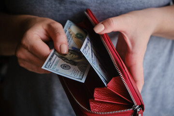 Close-up of woman taking money out of her purse.