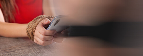 Obraz premium tied with a rope female hands hold the phone