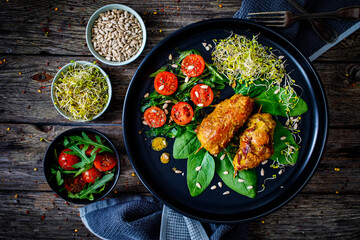 Wrapped pork with greens on wooden table
