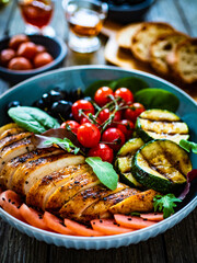 Keto diet - roasted chicken breast and vegetables on wooden table