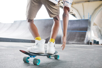 Close up of young teenage boy riding skateboard at skatepark outdoors, copy space