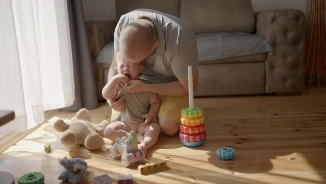 Parenting issues. portrait of upset cute asian american baby boy crying in fathers hands, teth pain feeling stressed and annoyed. Candid authentic real life working parenting. young little toddler boy
