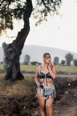 Latin woman in black and silver belly dance outfit in a field