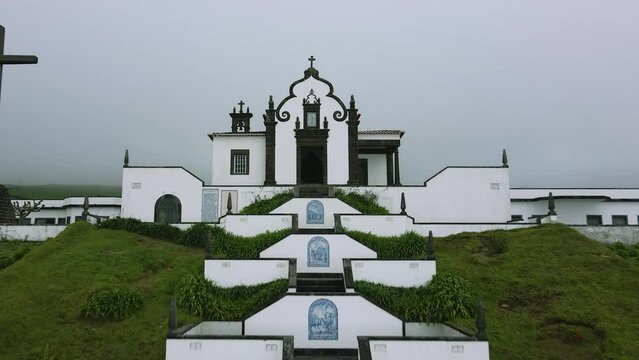 Beautiful chapel on a green hill in the fog - Chapel Ermida de Nossa Senhora, Azores, Sao Miquel, Portugal - 4k drone shot #1