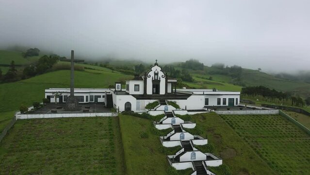 Beautiful chapel on a green hill in the fog - Chapel Ermida de Nossa Senhora, Azores, Sao Miquel, Portugal - 4k drone shot #2