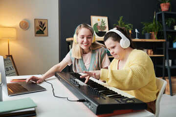Modern young woman with Down syndrome spending time with her best friend or sister creating audio...