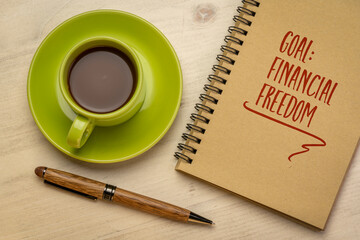 financial freedom - goal setting concept, handwriting in a notebook with a cup of coffee, personal...