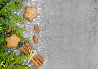 Fototapeta na wymiar Christmas winter background. Spicy ginger cookies, pretzels, flour. Copy space. Slate and snow. Fir twigs with cinnamon and almonds