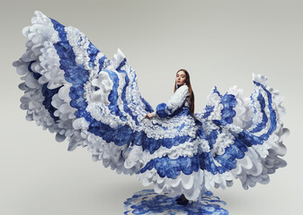 Woman in flying long wonderful dress with blue and white waves