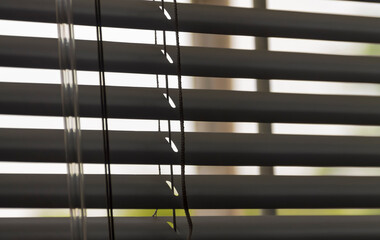 Sunlight coming through venetian blinds by the window, soft focus. Adobe RGB color space.