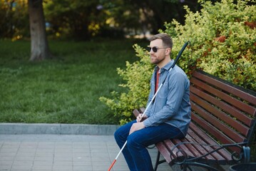 Obraz premium Blind man. People with disability, handicapped person and everyday life. Visually impaired man with walking stick.