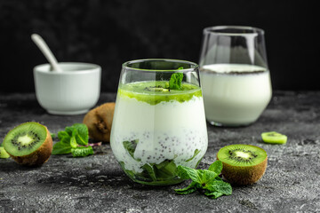 Healthy breakfast chia pudding with kiwi in glass jars on dark table. Clean eating, dieting, vegan food concept. banner, menu, recipe, place for text