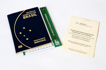 Two vaccination cards together with passport on a white table