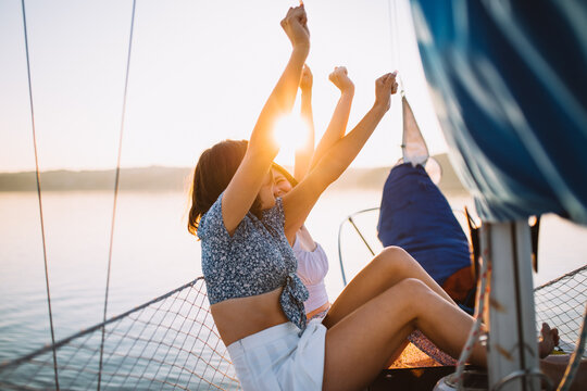 Happy ladies chatting during cruise on sea at sunset