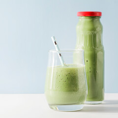 healthy green smoothie in glass, bottle with straw on blue background. Vegetarian healthy lifestyle concept.refreshing drink. quick snack. square