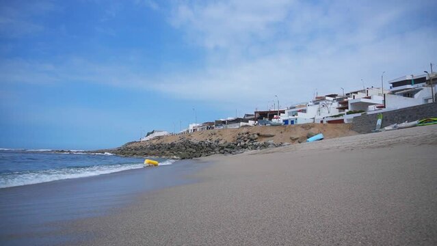 view from the sand walking on the shore of the sea at the Ladies beach and with the waves in Punta Hermosa, Lima, Peru