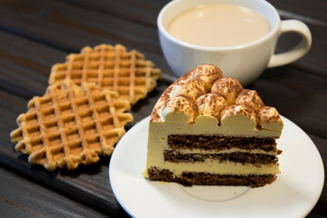 Piece of cake on white plate and waffles.