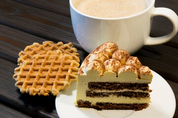 Piece of cake on white plate and waffles.