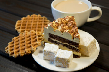 Piece of cake with turkish delight on white plate and waffles.