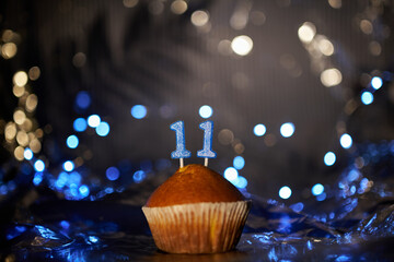 Holiday or birthday digital greeting card concept. Tasty vanilla cupcake or muffin with number 11...