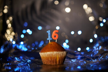 Digital gift card birthday concept. Tasty fresh homemade vanilla cupcake with number 16 sixteen on...
