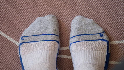 Male feet in socks standing on yoga mat closeup top view