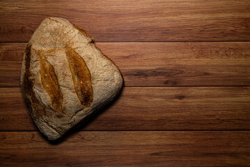 Freshly baked bread on a wooden table. Dark wood background and space for text