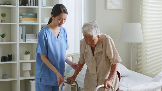 Young Asian woman nurse, caregiver, carer help and assist a senior Asian woman using a walking cane at home.