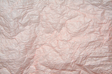 Crumpled pale pink wrapping paper texture background. Full frame of  creased packaging paper texture - abstract backdrop. Recycling concept or element of creative design