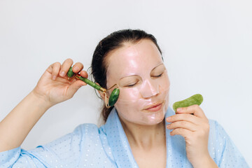 The girl makes a massage with a jade massager close-up, problem skin.