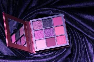 Velvet Violet eyeshadow palette on the background of luxurious velor fabric. The concept of trendy...
