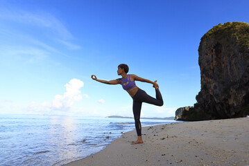 Woman doing yoga at the Railay beach at Krabi of Thailand, Outdoor Yoga exercise on beach, Healthy lifestyle