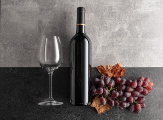 Red wine with grapes on a stone background.