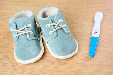 Blue shoes with pregnancy test on a table