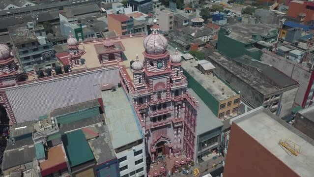  the famous grand Red Mosque (Jami Ul-Alfar Mosque) in the capital city of Colombo, Sri Lanka surrounded by other residential and commercial buildings on a bright sunny day