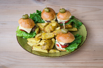 Mini Burgers on plate with potato fries.