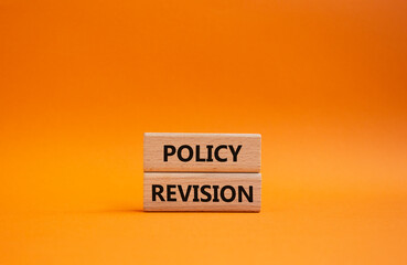 Policy revision symbol. Concept word Policy revision on wooden blocks. Beautiful orange background. Business and Policy revision concept. Copy space