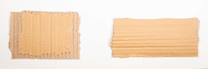 Fototapeta premium Two pieces of brown corrugated cardboard on white background. Blank ripped kraft carton paper note cards with copy space for text. Top view