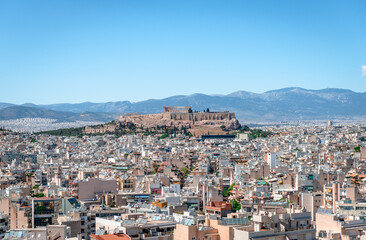 Fototapeta na wymiar The Athens skyline, seen from Kynosargous Hill. The Acropolis Hill with the Parthenon and the Odeon of Herodes Atticus dominates the picture.