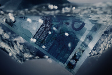 Macro image Euro banknote sinking in water. European financial crisis.