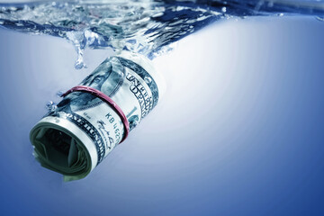 World economic crisis concept. US Dollar sinking in water as a symbol of global crisis. Copy space...